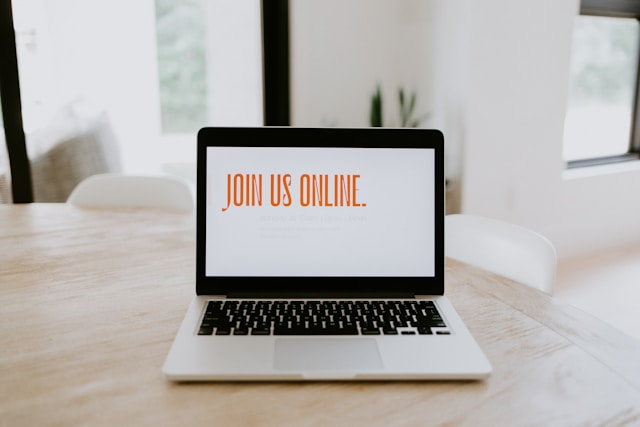 Image of a laptop open on a table. The screen is white except for orange text 'Join Us Online' 

Photo by Samantha Borges on Unsplash